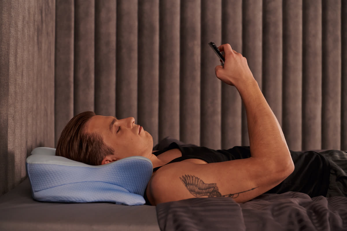 Side profile of a man on his back, chin level and airway unobstructed, resting on the contoured pillow